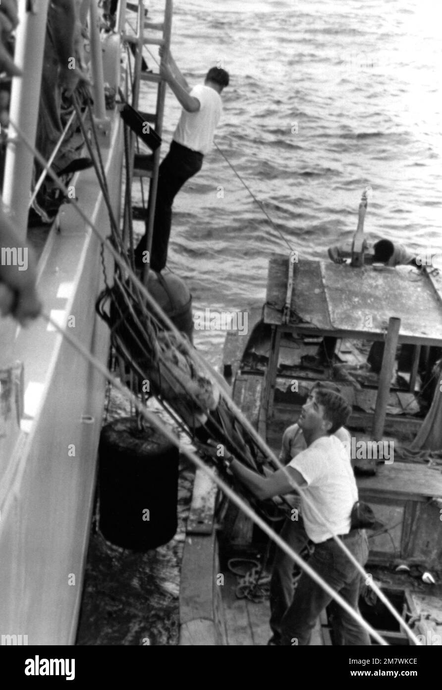 Crewmen from the guided missile cruiser USS FOX (CG-33) hoist a female ...