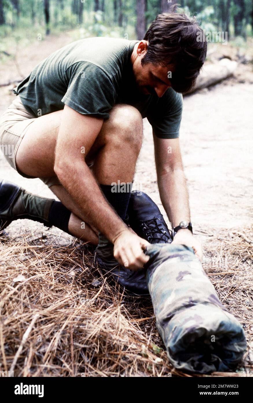 A Combat Control School students prepares a severed-leg decoy, which lies with an acting mutilated soldier. The student is participating in first aid training before becoming a Red Berets upon their graduation. Base: Pope Air Force Base State: North Carolina (NC) Country: United States Of America (USA) Stock Photo