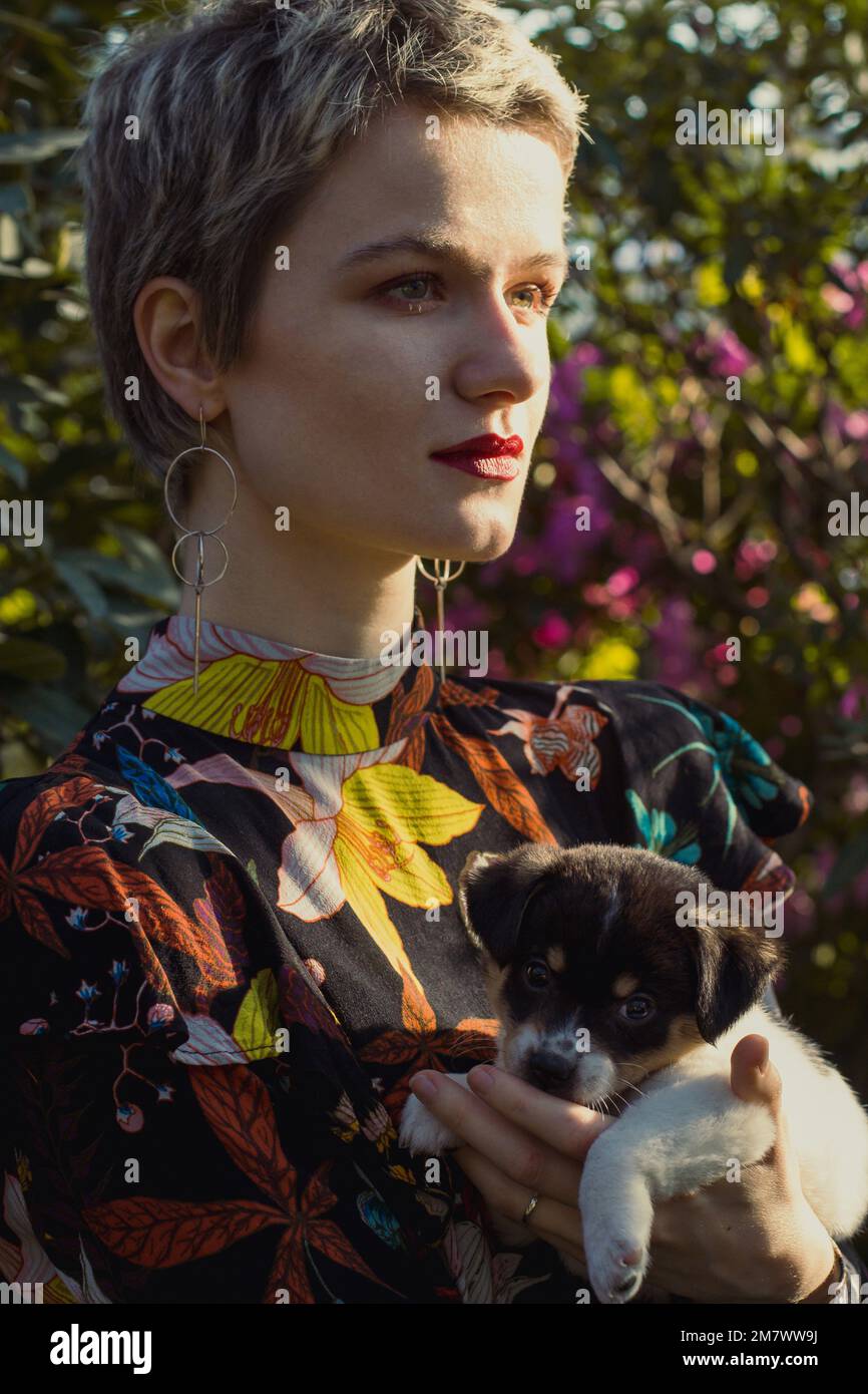 Close up short haired lady with puppy in orchard portrait picture Stock Photo