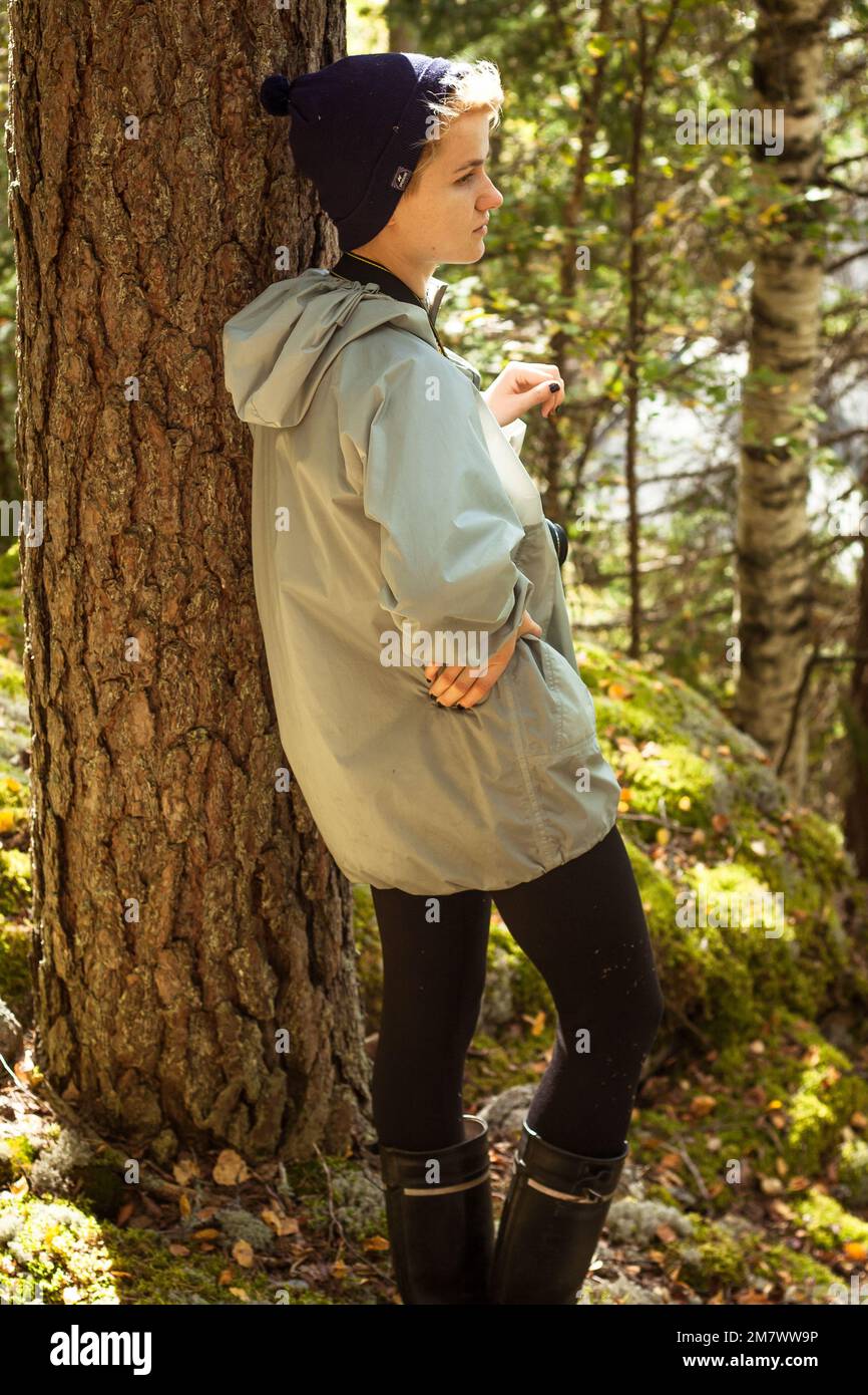 Female tourist leaning on tree in wood scenic photography Stock Photo