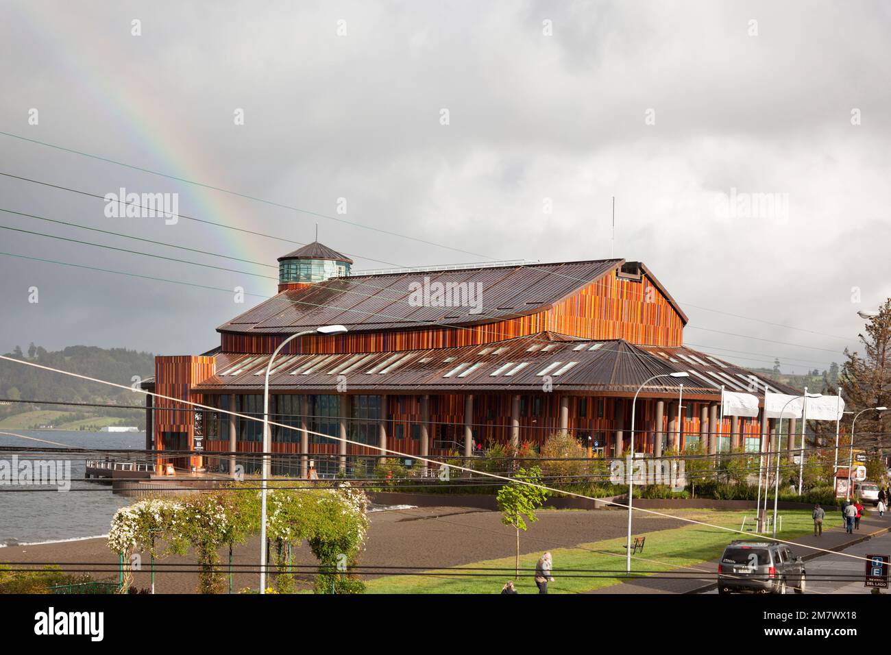 Frutillar, Chile-october 17, 2014: Rainbow over El Teatro del Lago. People walk after the rain in front of the theater of the lake. Stock Photo