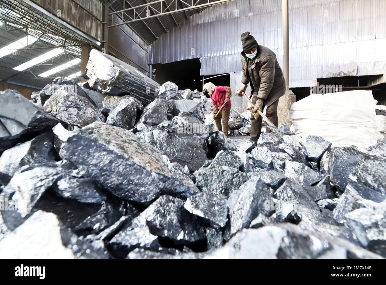 ZHANGYE, CHINA - JANUARY 10, 2023 - Workers crush metal silicon for packaging at a smelting plant in Zhangye city, Northwest China's Gansu province, J Stock Photo