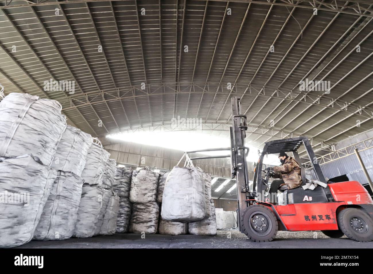 ZHANGYE, CHINA - JANUARY 10, 2023 - Workers load finished metal silicon at a smelting plant in Zhangye city, Northwest China's Gansu province, Jan 10, Stock Photo