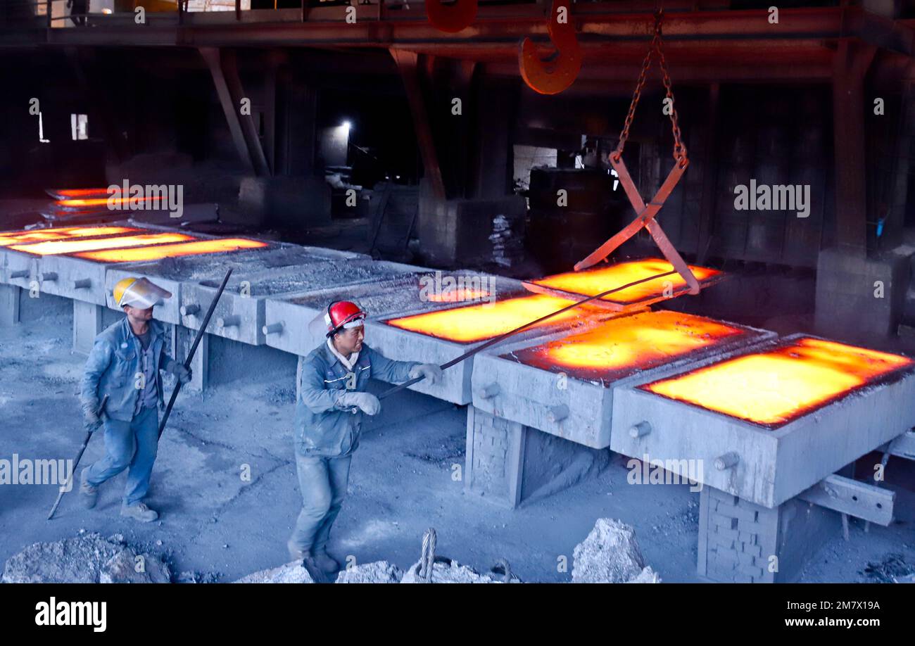 ZHANGYE, CHINA - JANUARY 10, 2023 - Workers lift finished metal silicon at a smelting plant in Zhangye city, Northwest China's Gansu province, Jan 10, Stock Photo
