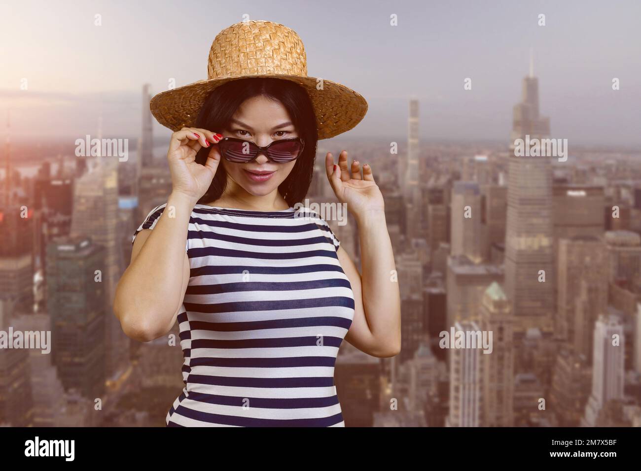 Portrait of attractive young asian woman in sunglasses and straw hat ...