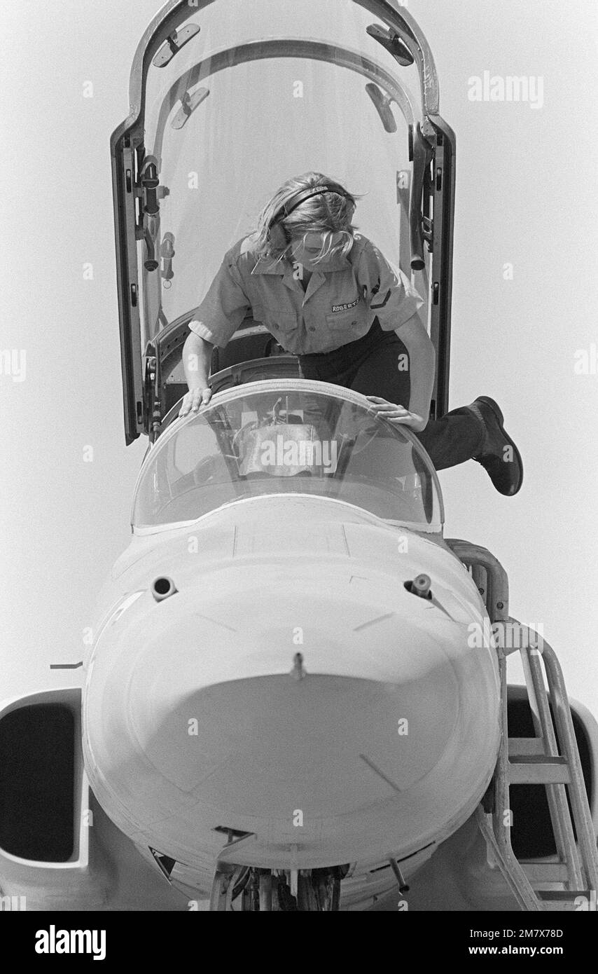 PETTY Officer 3rd Class Roberts climbs into the cockpit to service an F-5E Tiger II adversary aircraft assigned to the Navy Fighter Weapons School. Referred to as 'Top Gun,' the school provides air combat maneuvering (ACM) training for Navy and Marine Corps pilots. Base: Naval Air Station, Miramar State: California (CA) Country: United States Of America (USA) Stock Photo