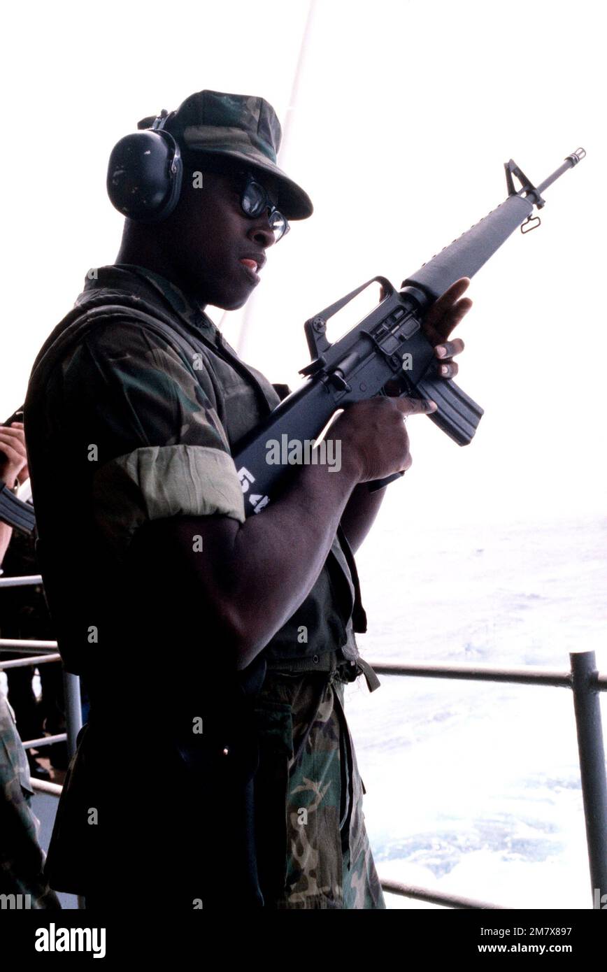 A Marine, armed with an M16A1 rifle, stands at the rail of the aircraft carrier USS AMERICA (CV 66). Base: USS America (CV 66) Country: Mediterranean Sea (MED) Stock Photo