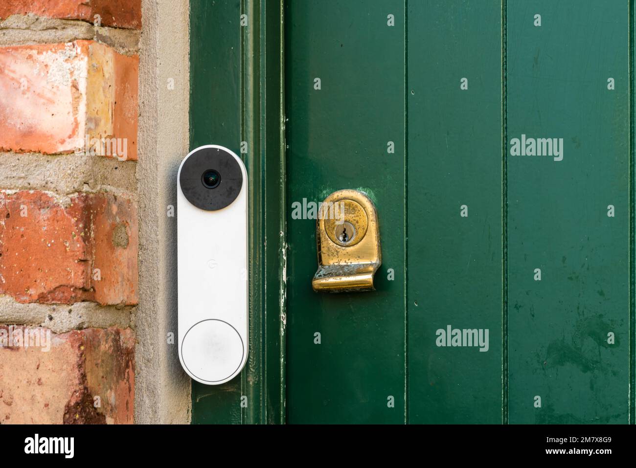 A video doorbell on a green door with a brass lock, United Kingdom, UK Stock Photo