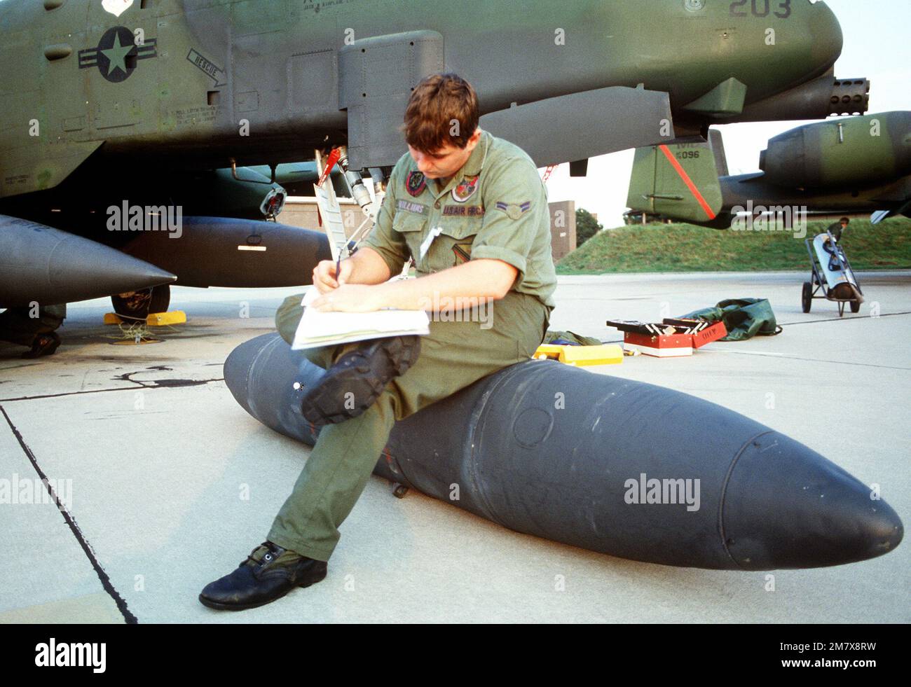 A ground crewman fills out a form after performing maintenance on an A ...