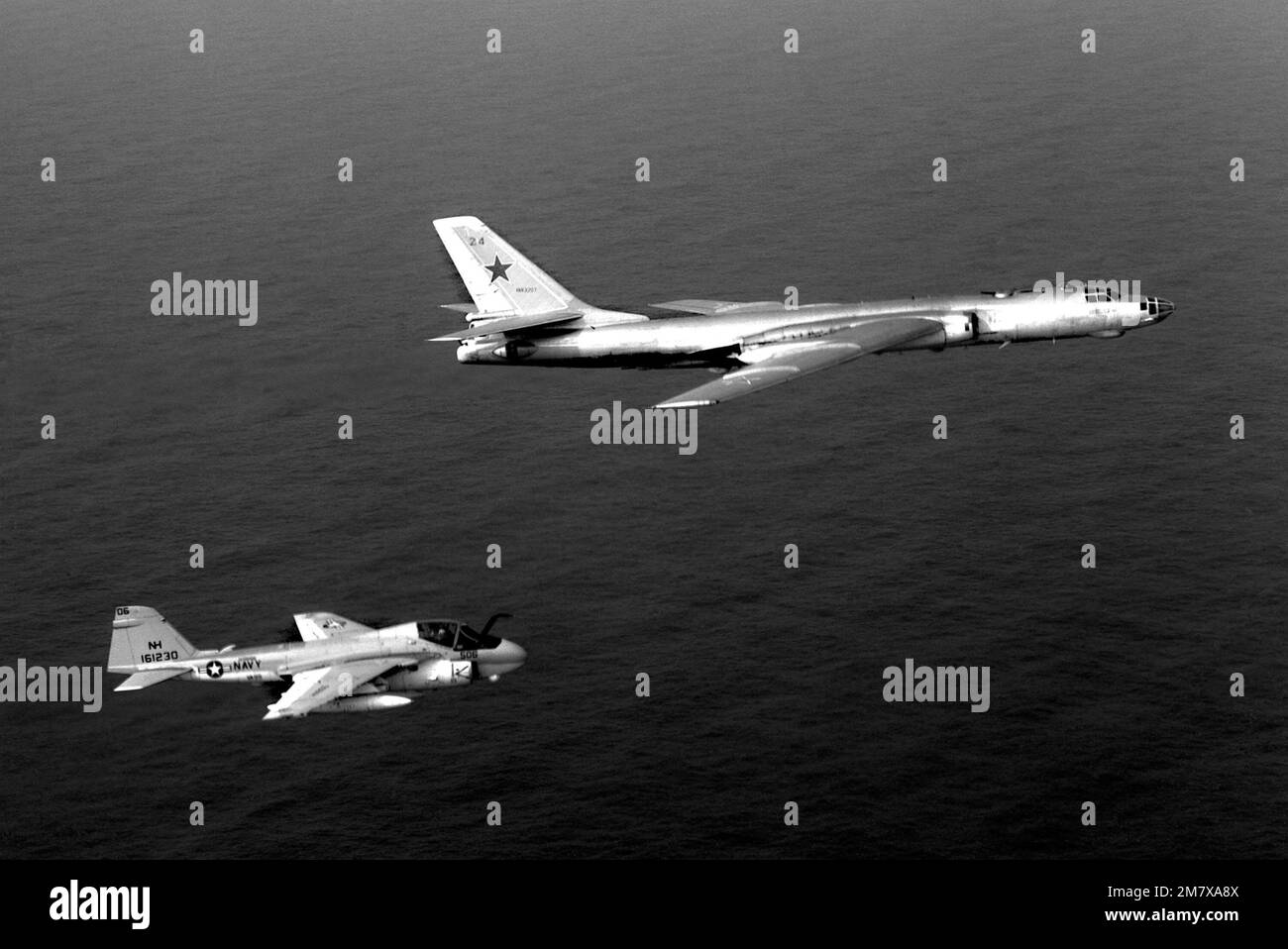 An air-to-air right side view of a Medium Attack Squadron 95 (VA-95) A-6E Intruder aircraft, assigned to the nuclear-powered aircraft carrier USS ENTERPRISE (CVN 65), escorting a Soviet Tu-16 Badger aircraft. Country: Pacific Ocean (POC) Stock Photo
