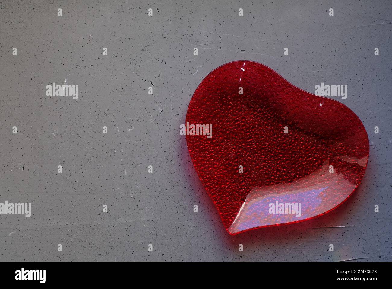A plate in the shape of a heart on grey background Stock Photo - Alamy
