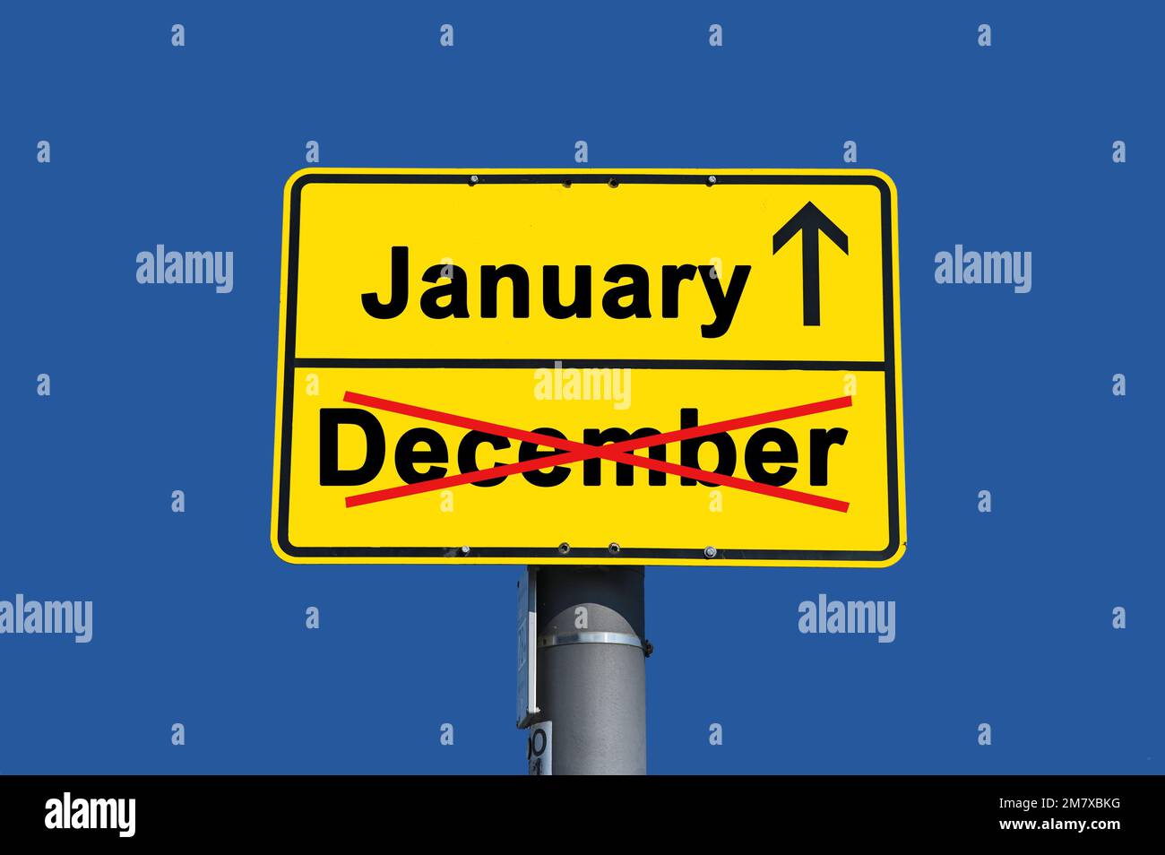 Yellow sign with black lettering. Below the word December crossed out in red and above it the word January with an arrow. Stock Photo