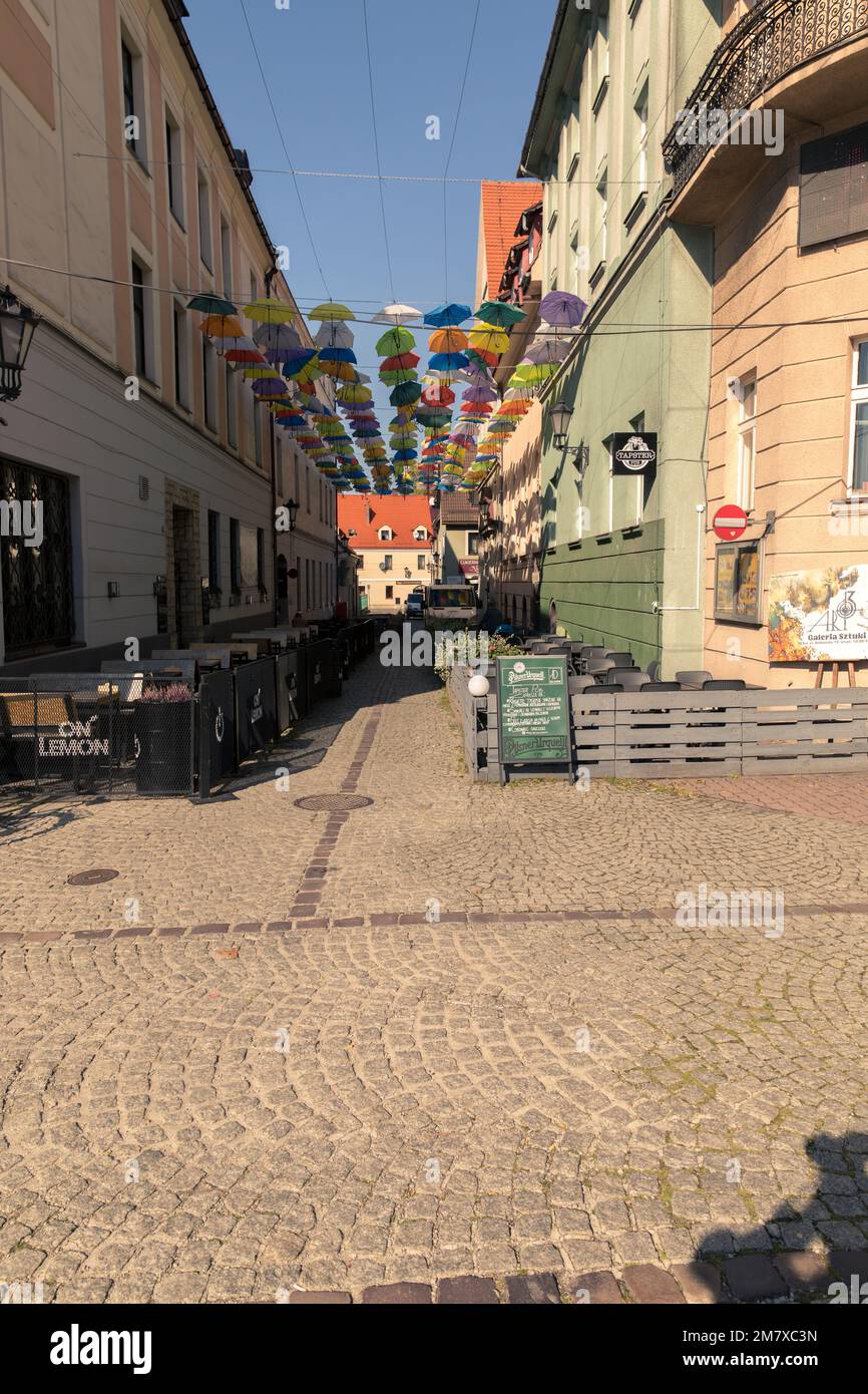 Colorful umbrellas hung above the street. Stock Photo