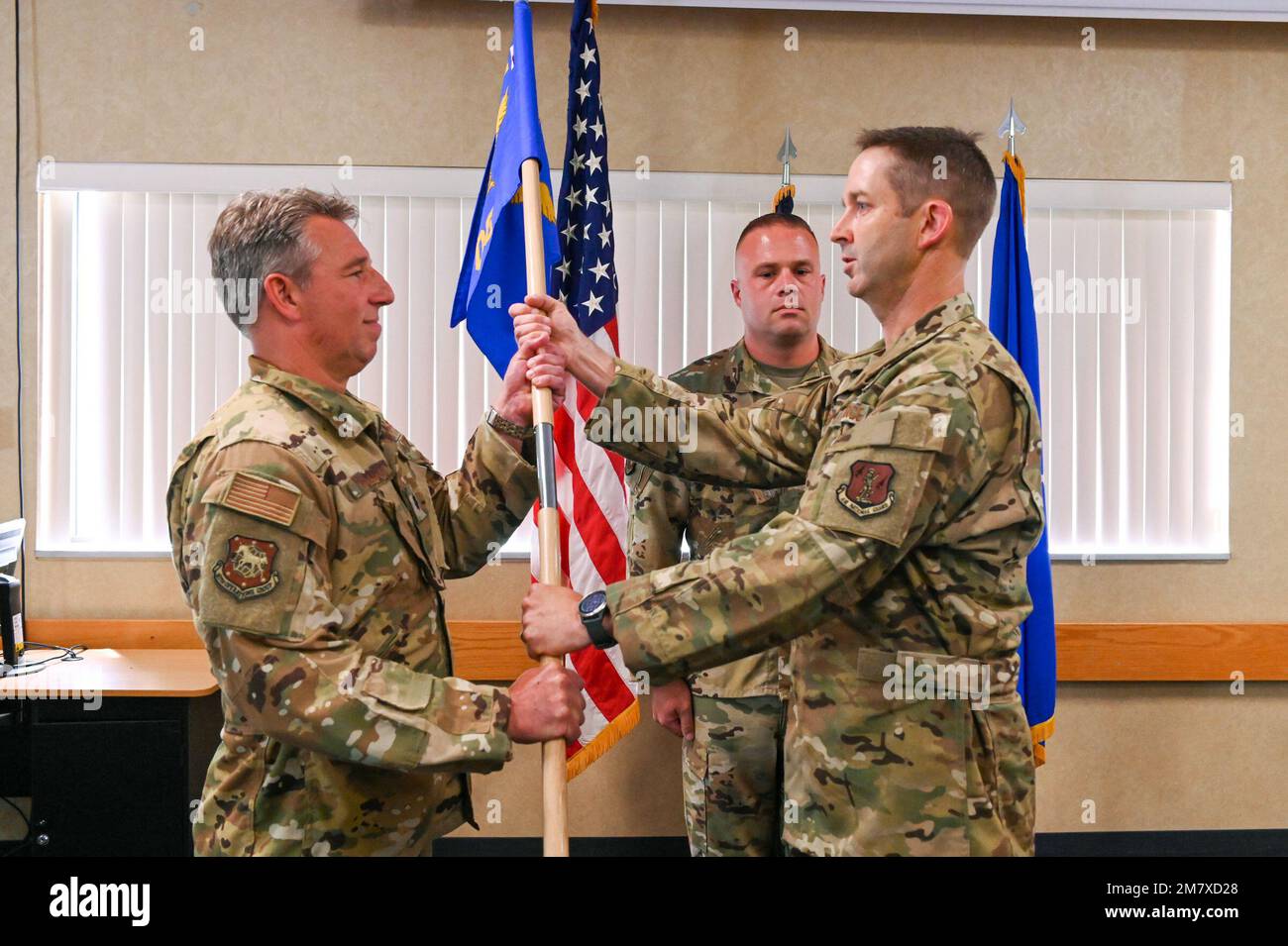 167th Operations Group deputy commander Lt. Col. John McCullough presents 167th Operations Support Squadron commander (OSS) Lt. Col. James Holsinger with the guidon during the OSS change of command ceremony held at the 167th base dining facility, Martinsburg, West Virginia, May 14, 2022. Air Force change of command ceremonies are a time-honored tradition where incoming commanders officially assume command while their airmen bear witness. Stock Photo