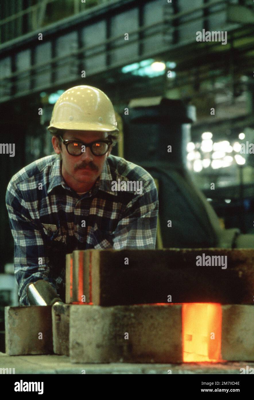 Michael Edwards, a shop 11 blacksmith, uses tongs to remove a piece of metal from the furnace. Base: Norfolk Naval Shipyard State: Virginia (VA) Country: United States Of America (USA) Stock Photo