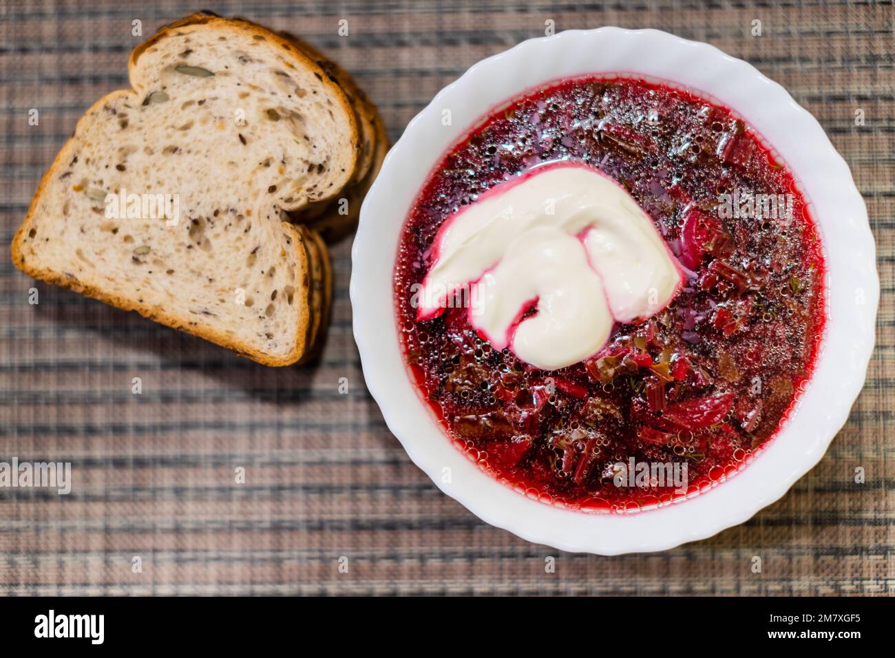 Borscht - sour soup common in Eastern Europe - made with red beetroots and sour cream - piece of bread Stock Photo