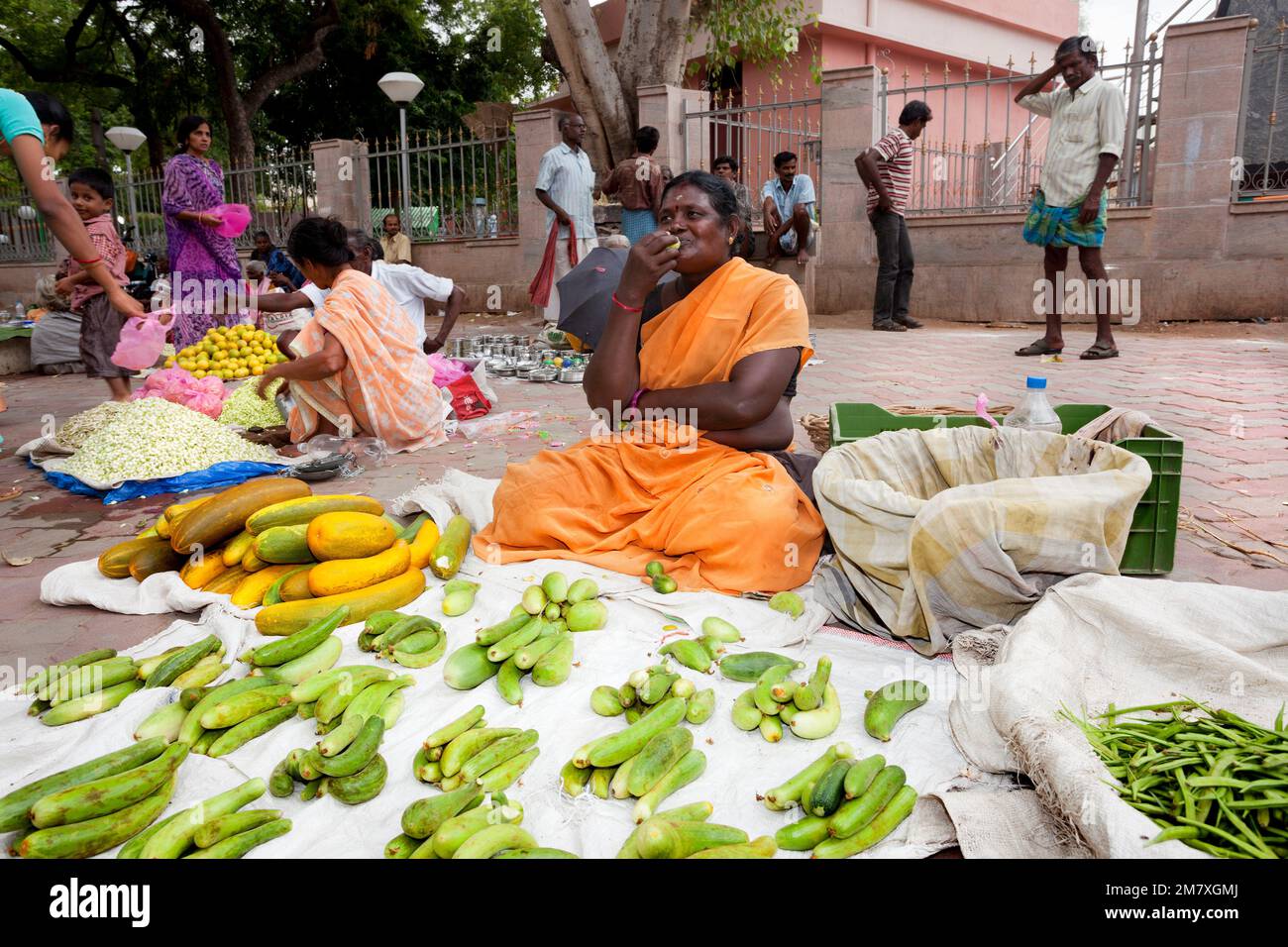 Madurai, India-September 11, 2012. In evening market in the city of Madurai in India, in the monsoon season, vendor eat some fuits while waiting for a Stock Photo