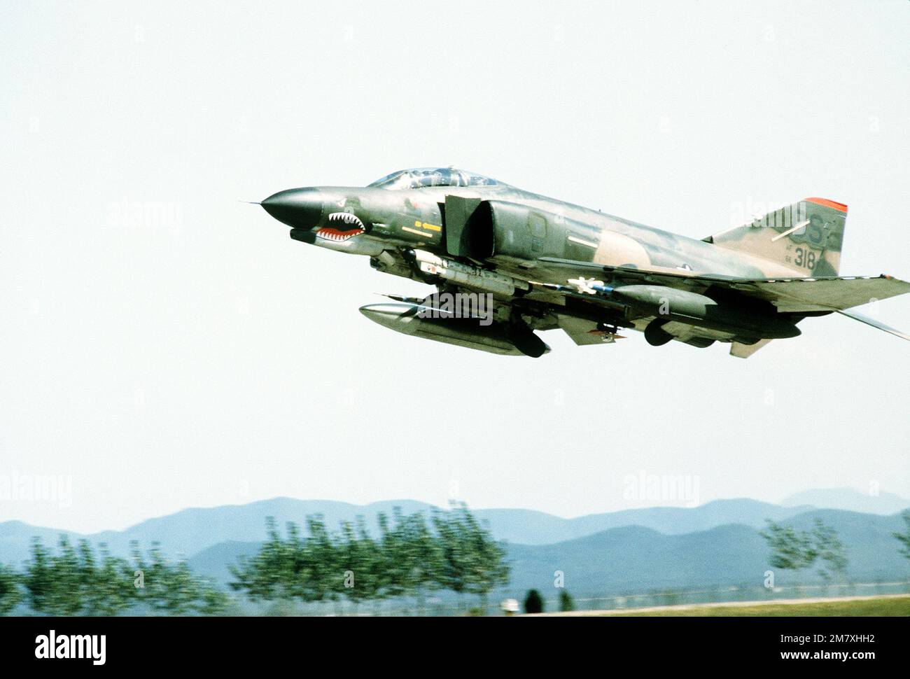 F-4 Phantom II aircraft takes off with an Air Combat Maneuvering Instrumentation pod and reflective laser devise attached to a wing pylon. Base: Osan Air Base Country: Republic Of Korea (KOR) Stock Photo