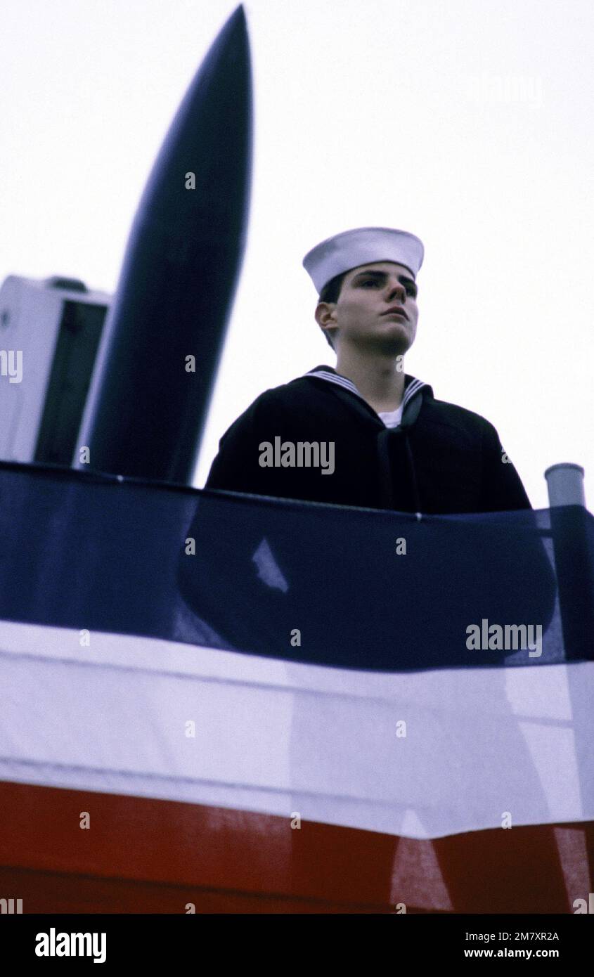 A crewman aboard the guided missile frigate USS AUBREY FITCH 9FFG-34) stands at parade rest in front of the Mark 13 Mod Four launcher for Standard-MR SAM and Harpoon missiles, during the ship's commissioning ceremony. Base: Bath State: Maine (ME) Country: United States Of America (USA) Stock Photo
