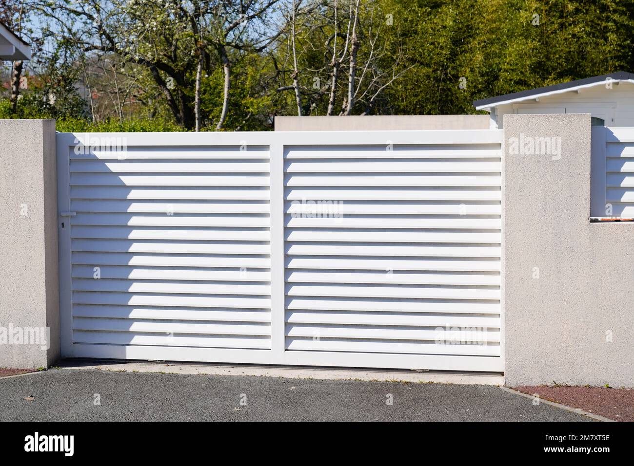 steel white slide gate aluminum portal with blades of suburban house Stock Photo