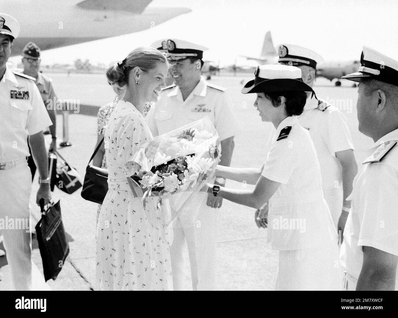 Mrs. John Lehman, wife of secretary of the Navy, receives welcome aboard flowers from a Japanese Maritime Self Defense Force Officer, upon arriving with her husband for a tour of the facility. Base: Naval Air Facility, Atsugi Country: Japan (JPN) Stock Photo
