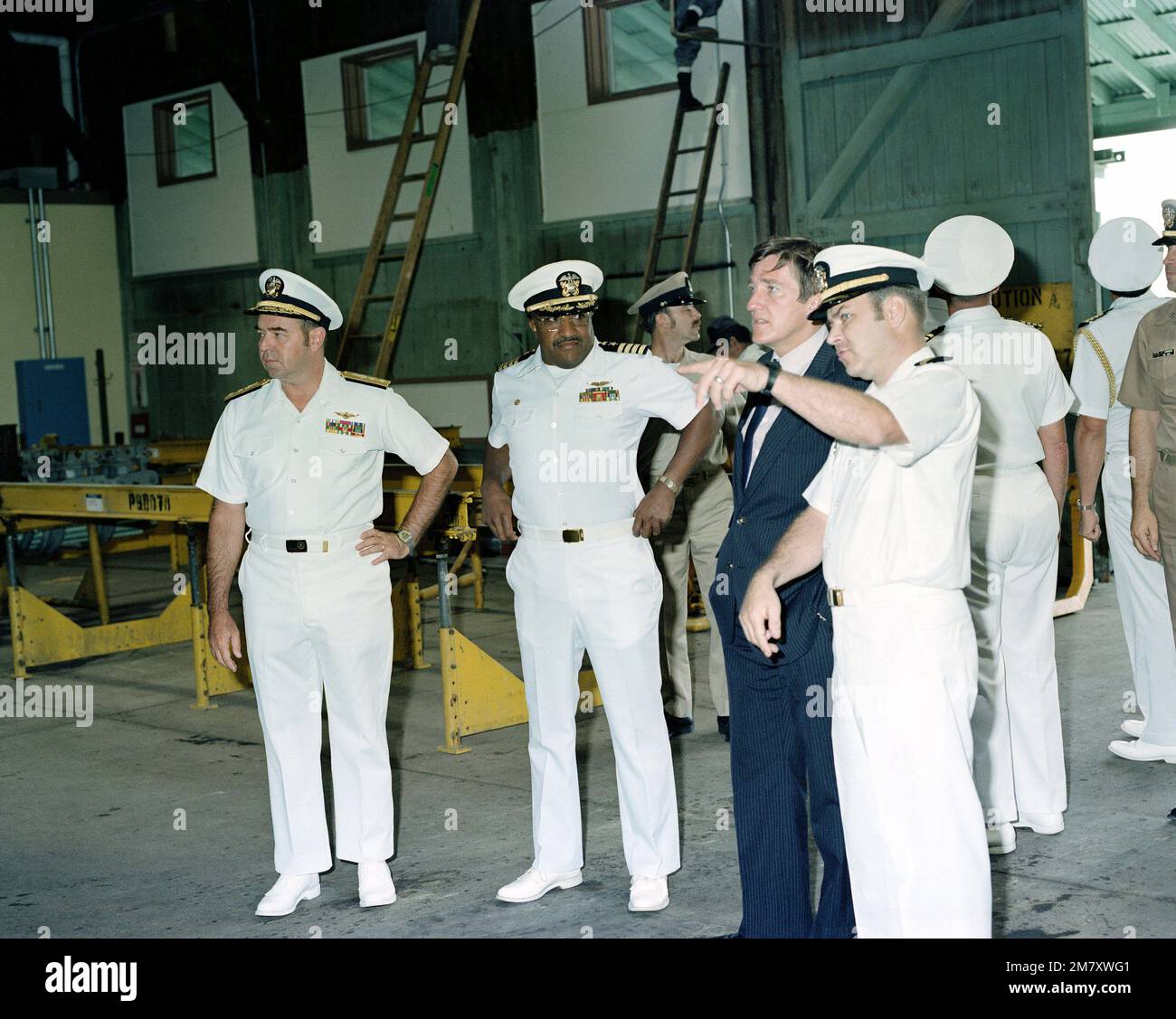 Secretary of the Navy John Lehman is given a tour of the hangar spaces at the facility. Captain Brooks, Naval Air Facility commanding officer, stands to the right of Mr. Lehman. Base: Naval Air Facility, Atsugi Country: Japan (JPN) Stock Photo