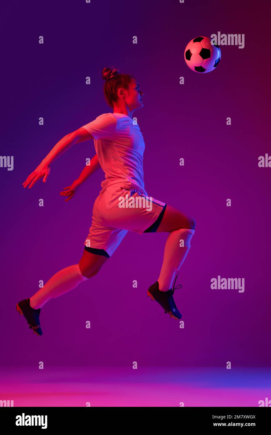 Head kick. Young professional female football, soccer player in motion