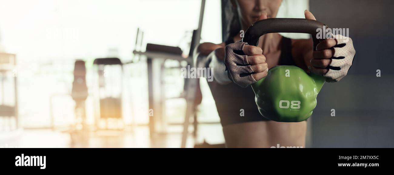 Close up of young woman doing exerce with kettlebell in gym. Stock Photo