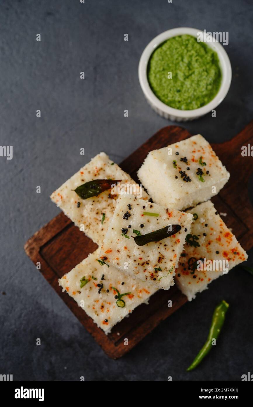 Spongy white dhokla popular Gujarati steamed breakfast with rice or rava served with green