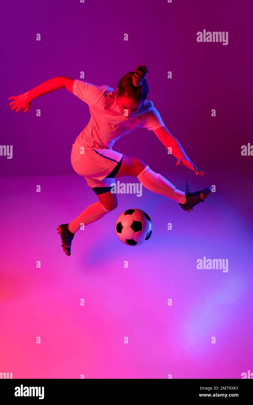 Dribbling. Young professional female football, soccer player in motion, training, playing over
