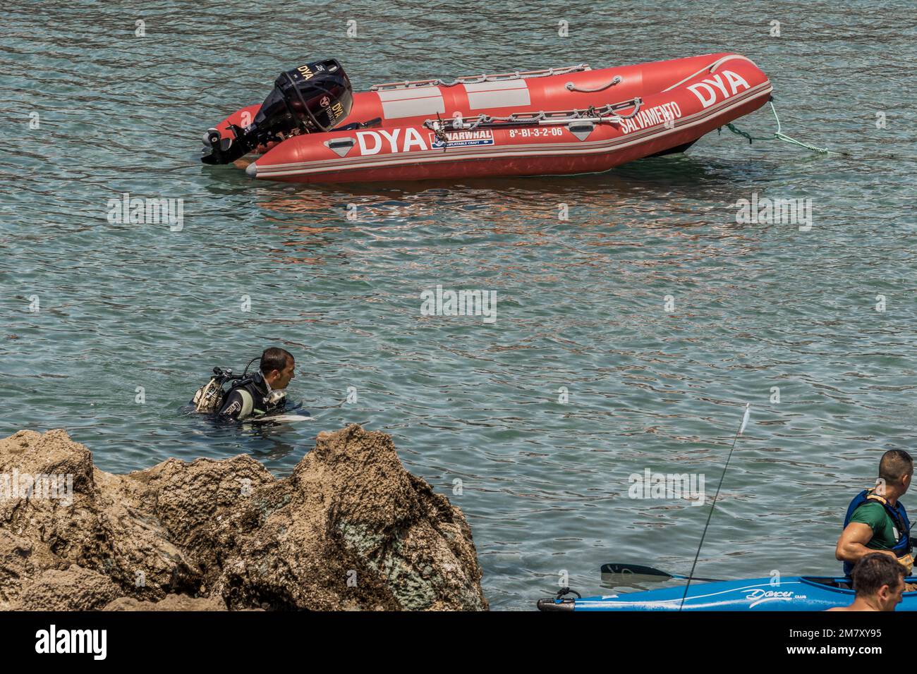 People watching a mock training of DYA divers, canoes and rescue boats in the small town of Islares, Cantabria, Spain Stock Photo