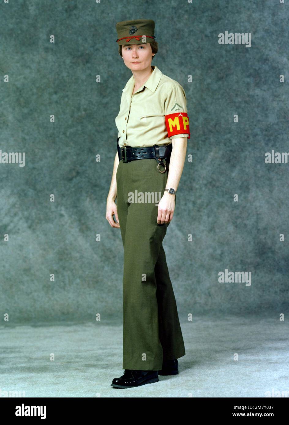 A woman Marine, military police Lance CPL. is dressed in green slacks, green cap, khaki blouse, MP arm band, and a pistol belt. Base: Marine Corps Dev&Ec, Quantico State: Virginia (VA) Country: United States Of America (USA) Stock Photo