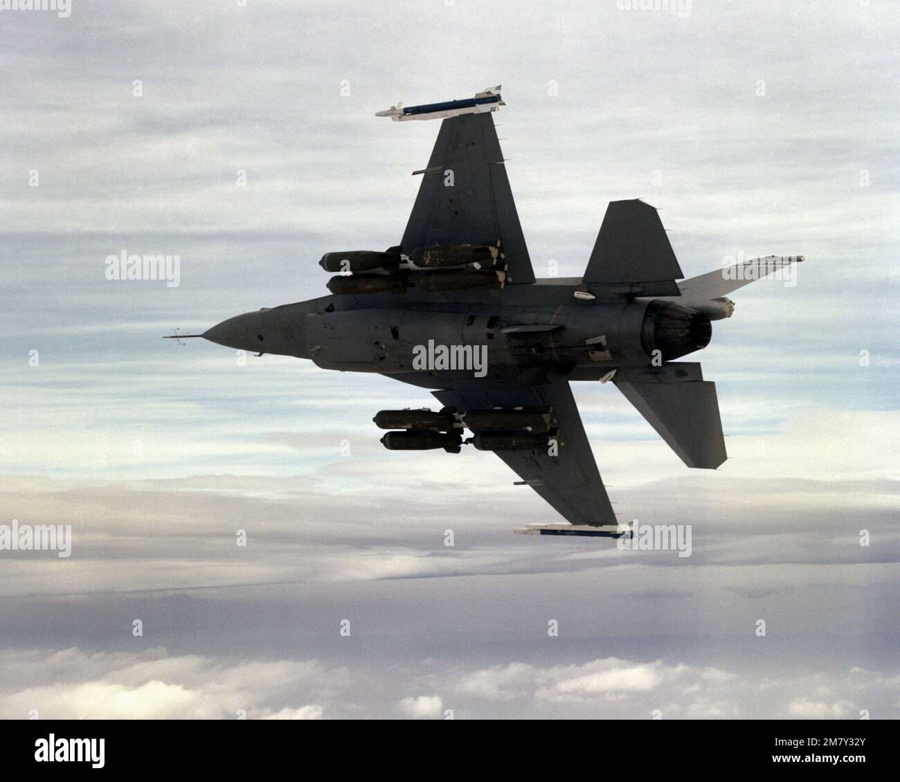 An air-to-air left underside view of an F-16A Fighting Falcon aircraft ...