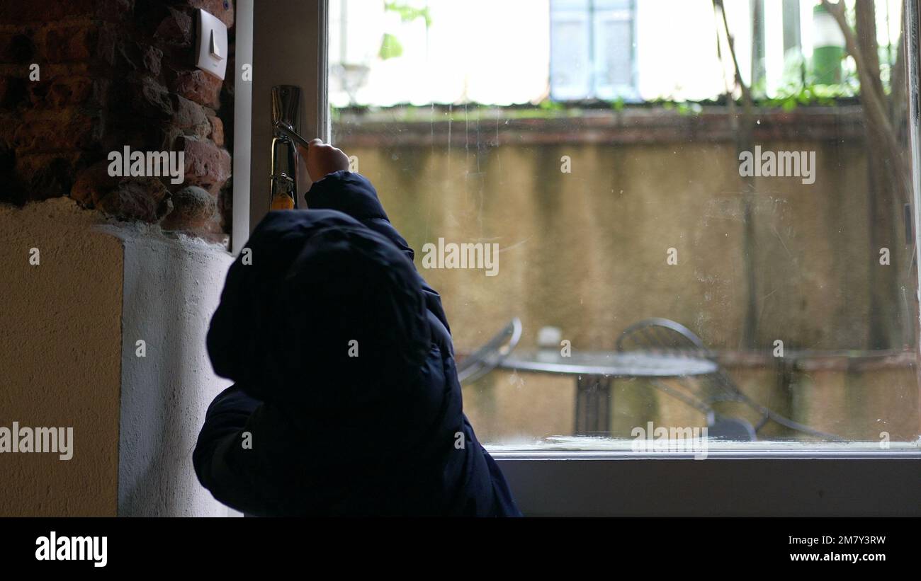 Toddler baby opening front door, stepping out. Child reaching doorknob exiting house Stock Photo