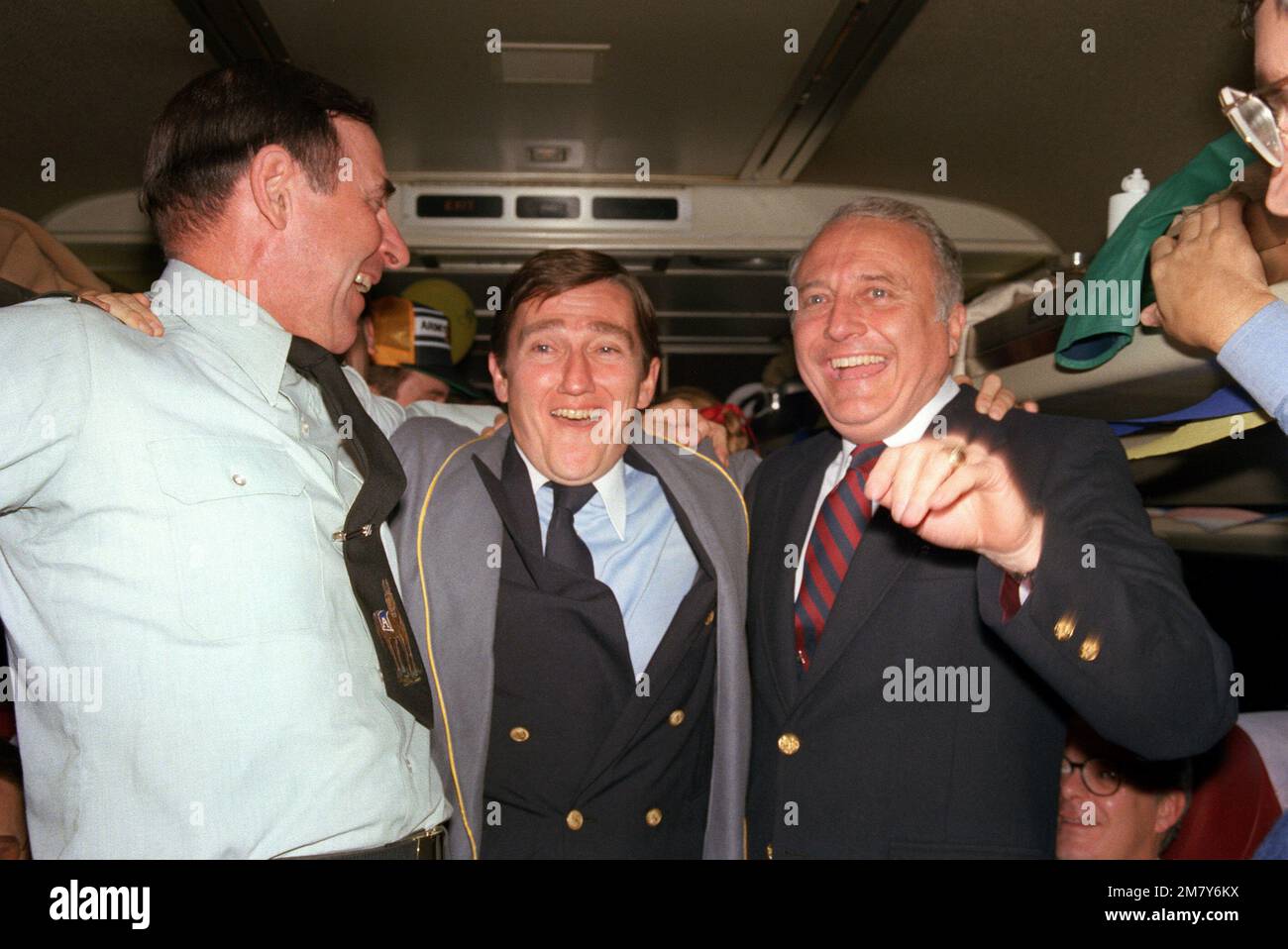 While returning by train from Philadelphia, Secretary of the Navy John Lehman dons a West Point cadet robe as a token of victory in the Army-Navy football game. He is flanked by GEN E. C. Meyer, Army chief of staff (left) and Secretary of the Army, John O. Marsh. Base: Arlington State: Virginia (VA) Country: United States Of America (USA) Stock Photo