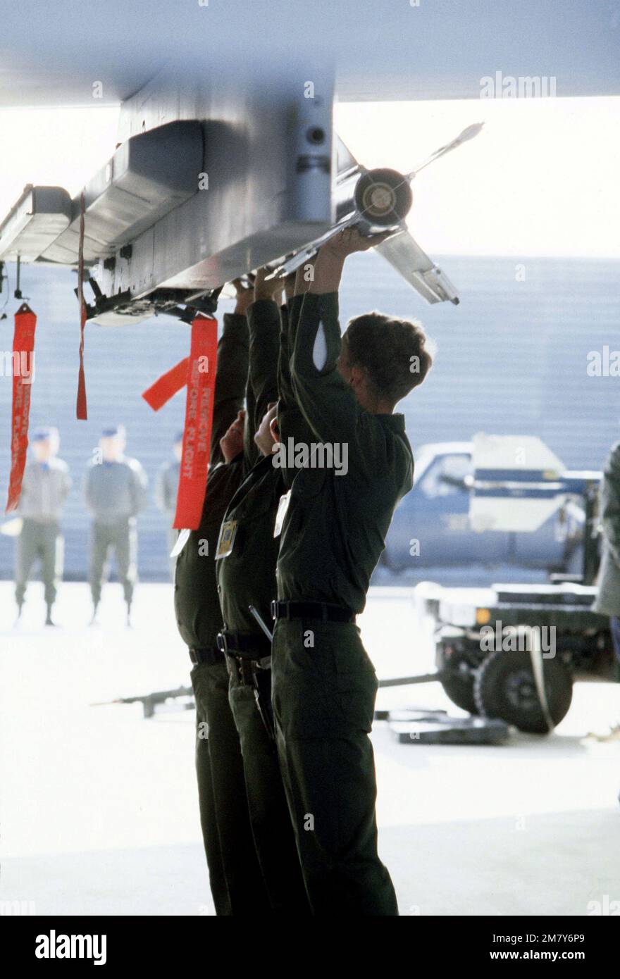 A loading crew attaches an AIM-9P Sidewinder missile to the wing pylon of an F-15 Eagle aircraft during munitions loading competition Sabre Spirit I. Subject Operation/Series: SABRE SPIRIT I Base: Osan Air Base Country: Republic Of Korea (KOR) Stock Photo