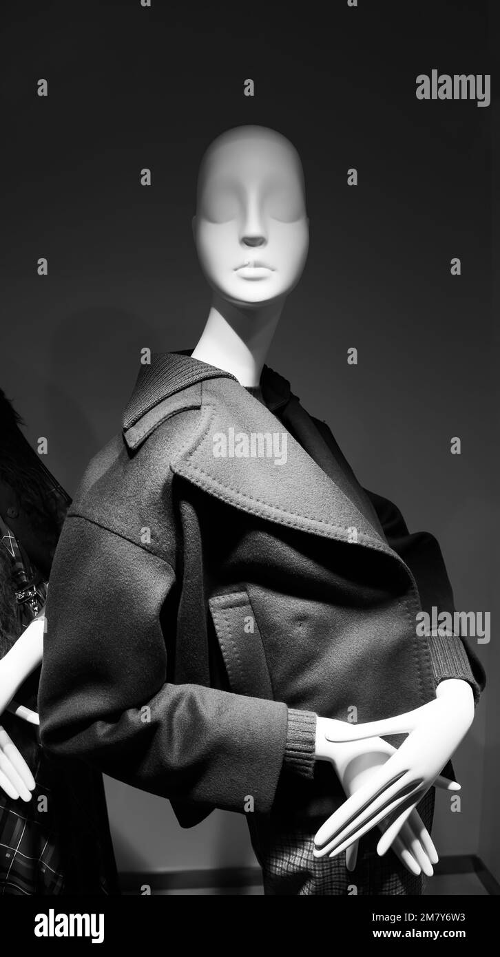 Mannequin wearing a luxury coat seen through the window - elegance at superlative black and white photograph Stock Photo