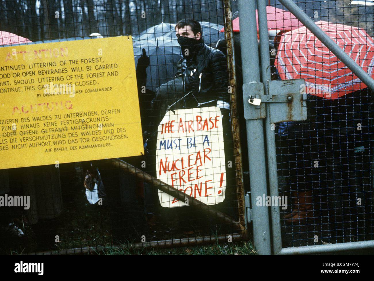 A protester expresses his views with a poster outside the Waldorf gate. The protester was part of a group of approximately 300 who were demonstrating against NATO's decision to deploy Pershing II and cruise missiles in Western Europe. Base: Rhein-Main Air Base Country: Deutschland / Germany (DEU) Stock Photo