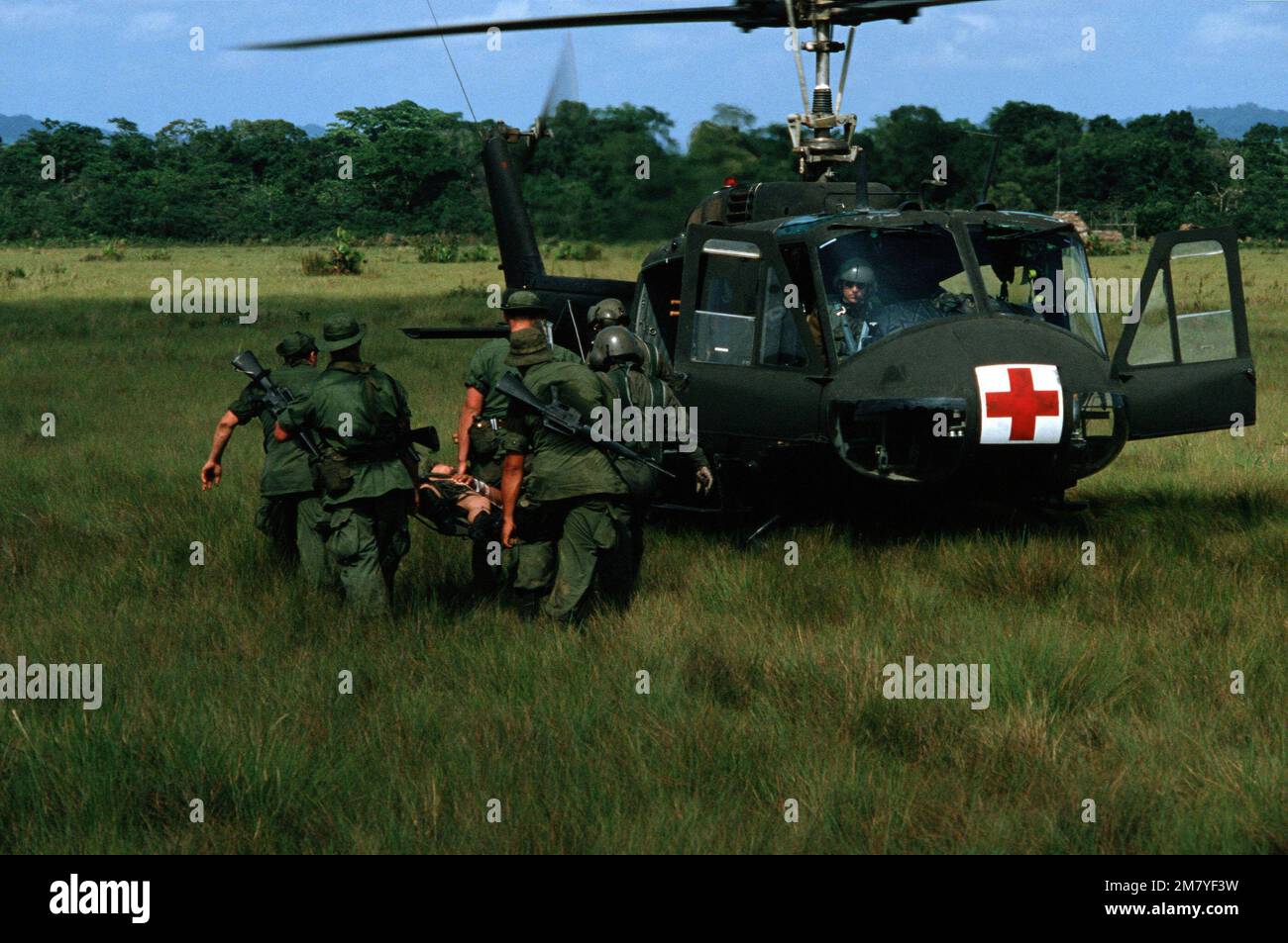 An injured Honduran Army soldier is carried to a waiting UH-1H Iroquois helicopter for transportation to a hospital during the combined United States/Honduran training operation 'AHUAS TARA' (BIG PINE). Subject Operation/Series: AHUAS TARA (BIG PINE) Country: Honduras (HND) Stock Photo