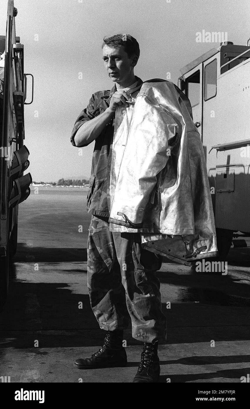 SSGT John Rogers, a reservist with Marine Air Base Squadron 41, puts on his asbestos fire retardant suit prior to putting out an oil fire during his annual two-week training. Base: Marine Corps Air Station, Yuma State: Arizona (AZ) Country: United States Of America (USA) Stock Photo