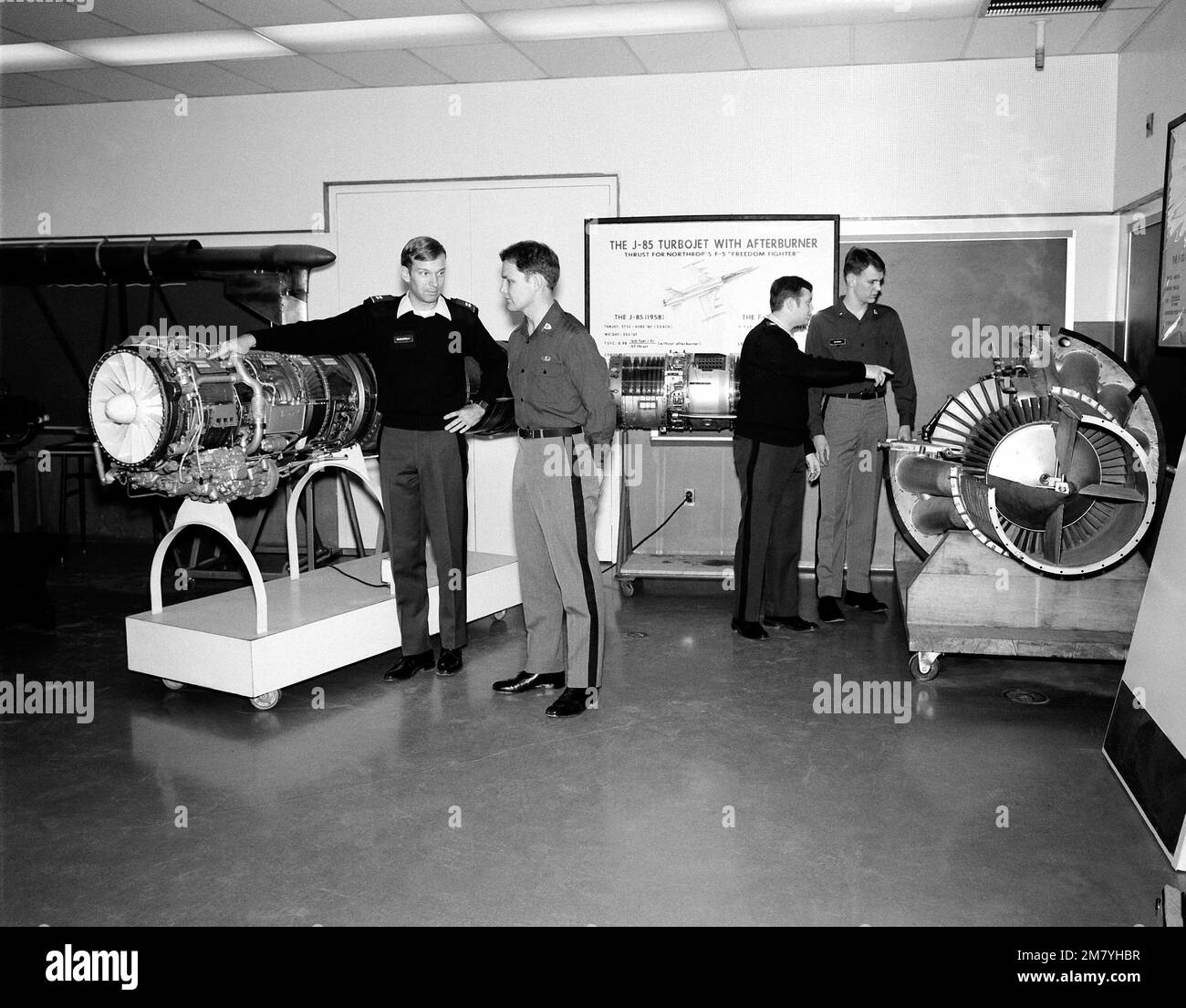 Training officers use models of jet aircraft engines to instruct cadets