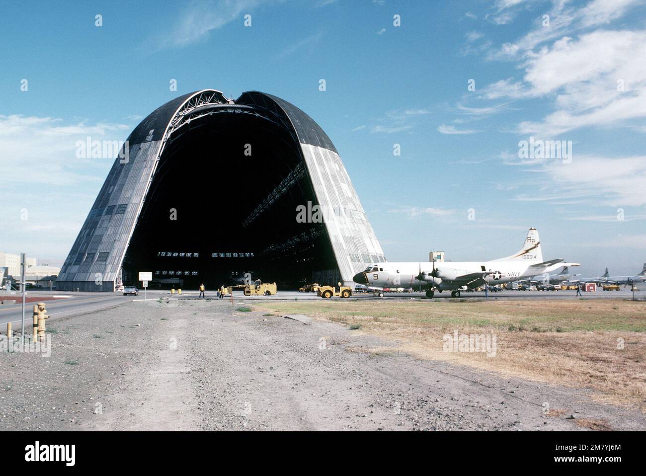 A left side view of a Patrol Squadron 31 (VP-31) P-3 Orion aircraft parked near a hangar previously used for blimps. Base: Naval Air Station, Moffett Field State: California (CA) Country: United States Of America (USA) Stock Photo