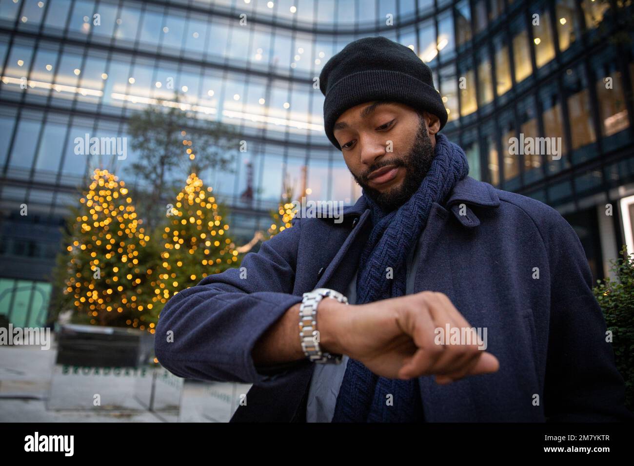 African businessman checks the time from his watch on a winter day Stock Photo