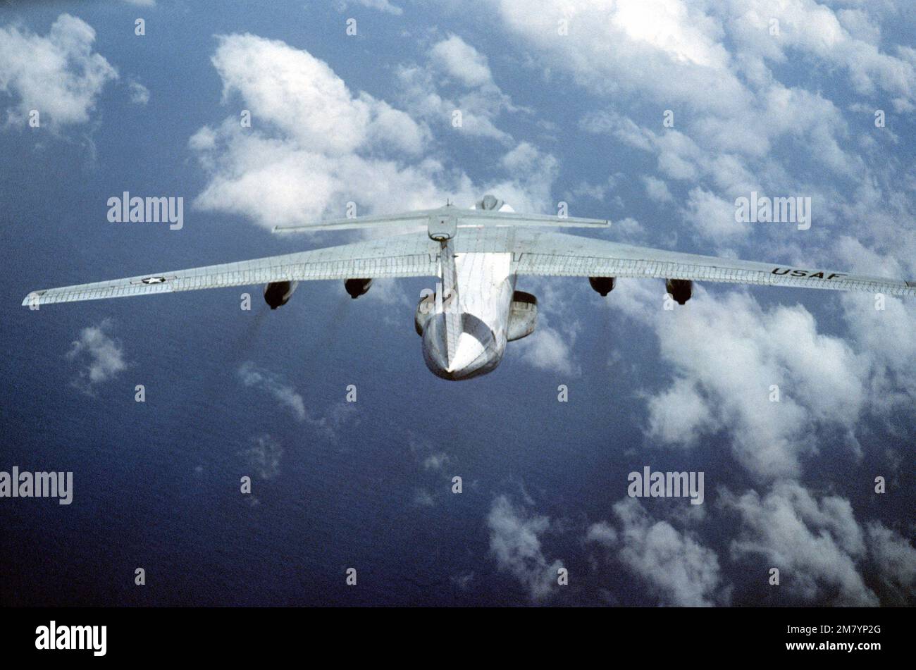 An air-to-air top rear view of a C-141B Starlifter aircraft from the ...