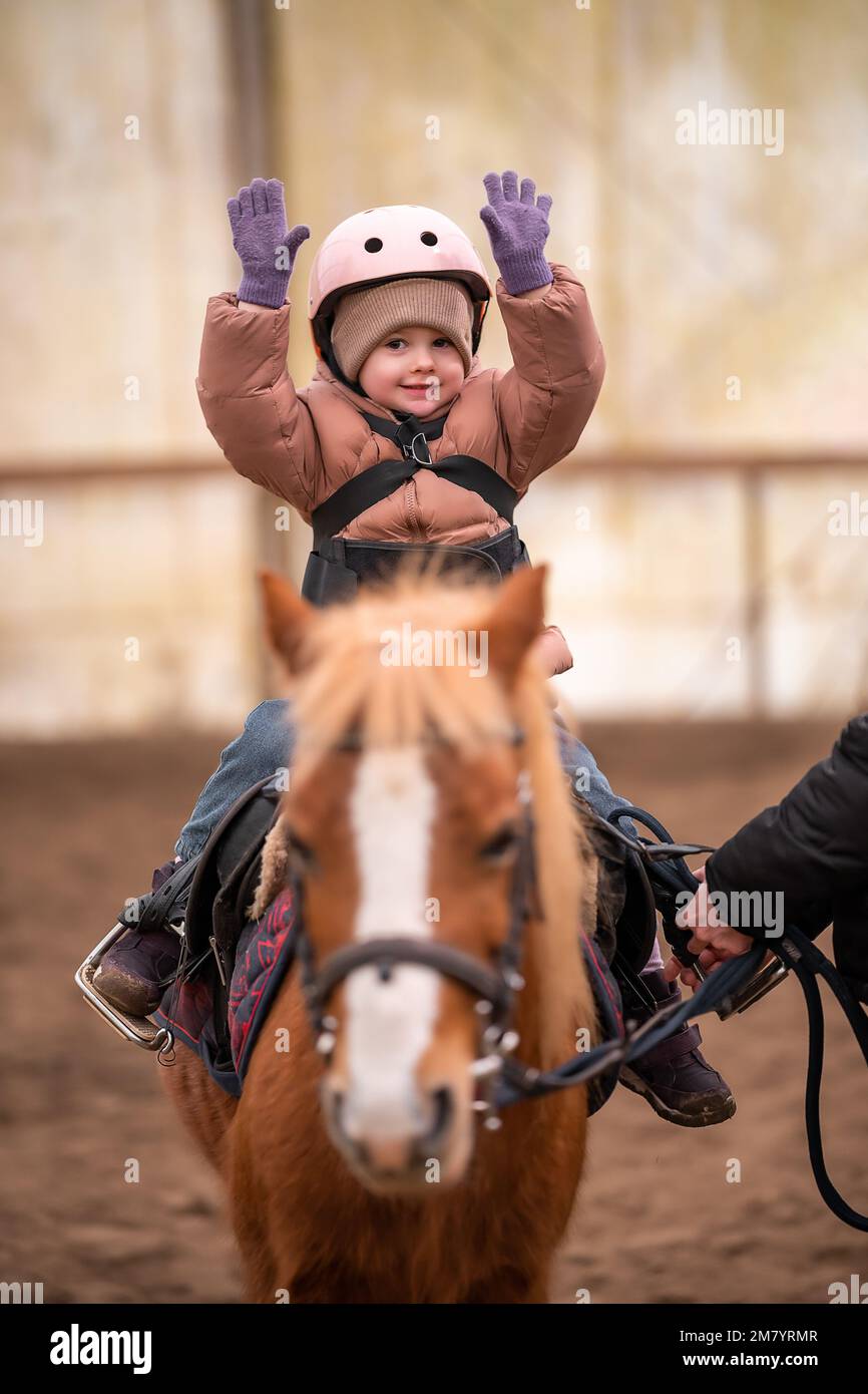 Little Child Riding Lesson. Threeyearold girl rides a pony and does