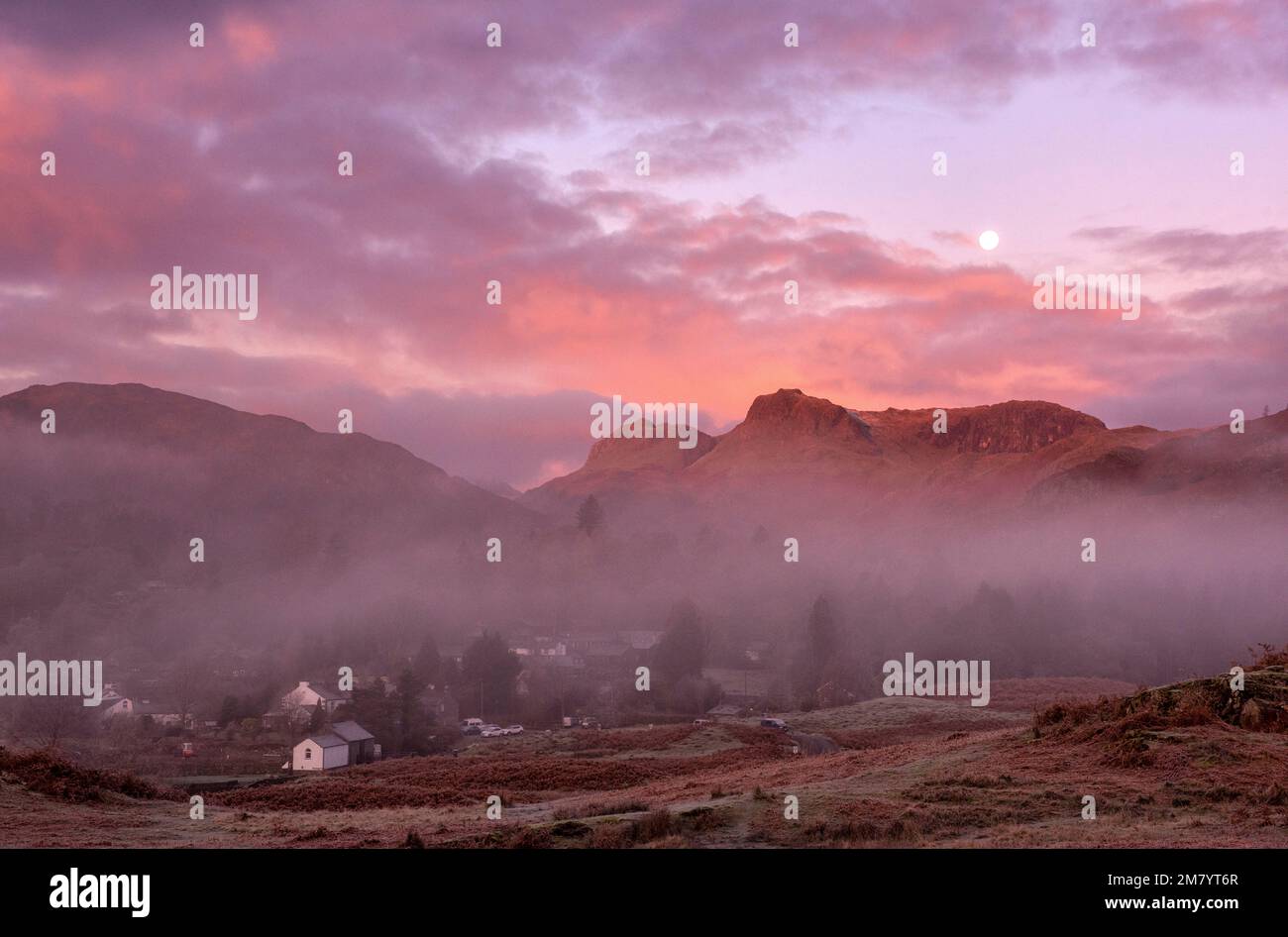 Sunrise view over Elterwater Village towards the Langdale Pikes, Lake District England UK Stock Photo