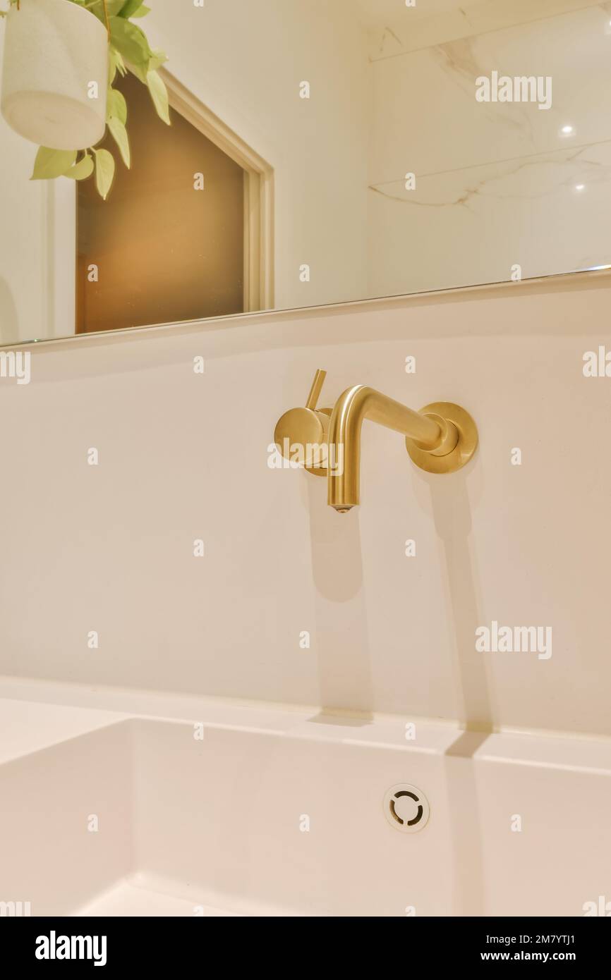 a white bathroom sink with gold fauced handles and brass fixtures on the wall mounted fauced