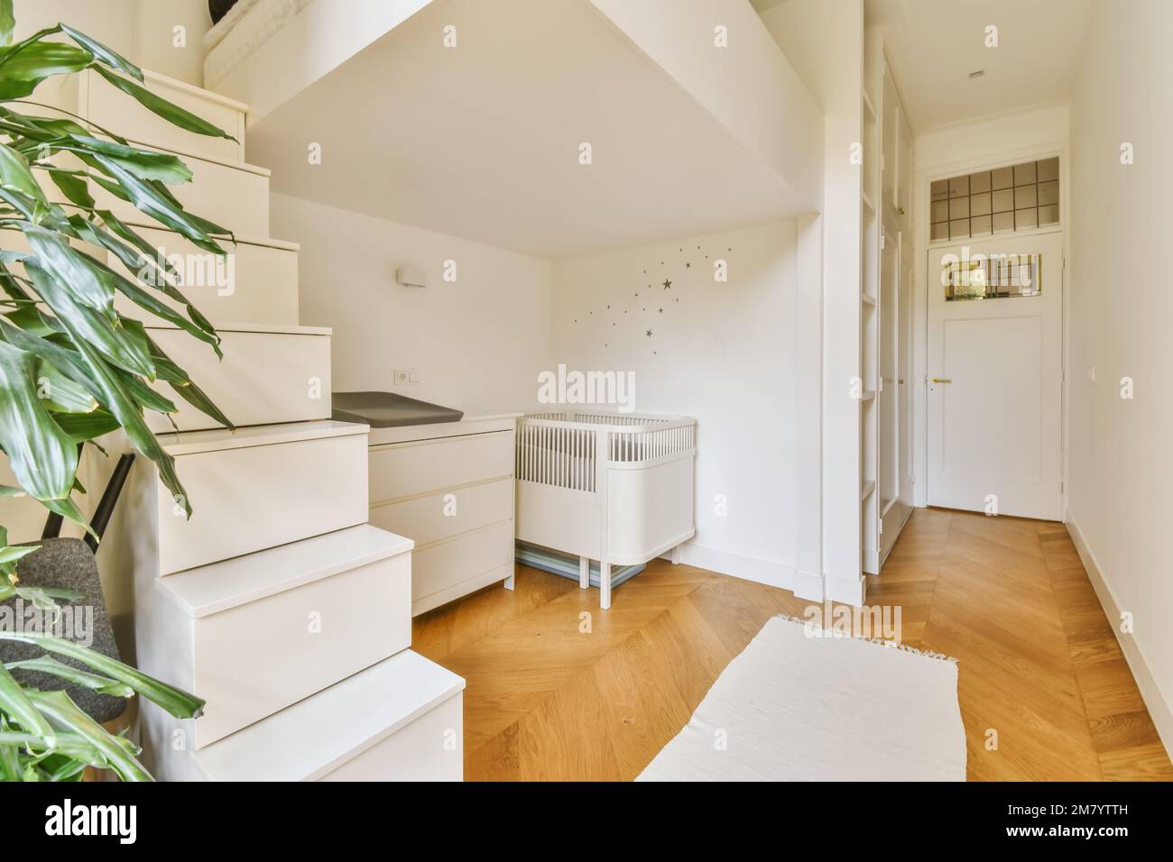 a white room with wooden flooring and an air condition heater on the ...