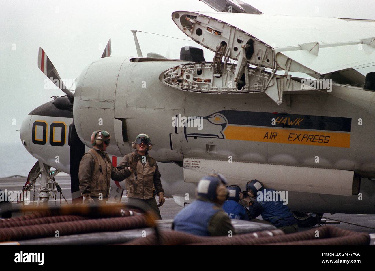 Crewmembers secure a C-1A Trader cargo/transport aircraft to the flight deck of the aircraft carrier USS KITTY HAWK (CV 63). Base: USS Kitty Hawk (CV 63) Stock Photo