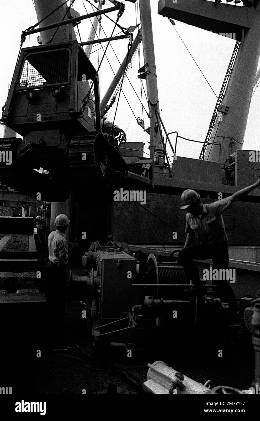 Seabees load heavy equipment aboard the amphibious cargo ship USS